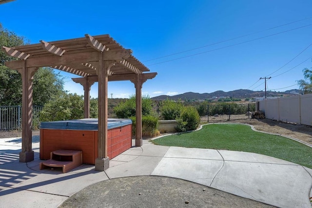 view of patio with a hot tub, a mountain view, and a pergola