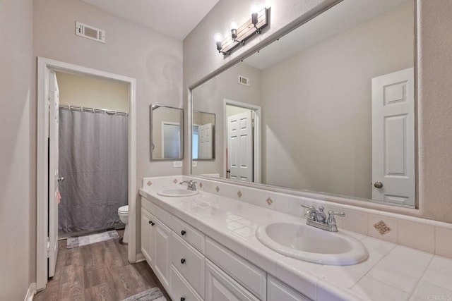 bathroom featuring vanity, hardwood / wood-style floors, a shower with curtain, and toilet