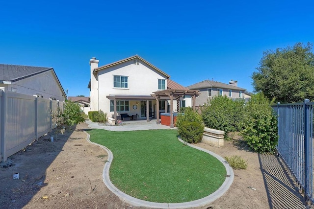 back of house featuring a patio, a yard, and a pergola