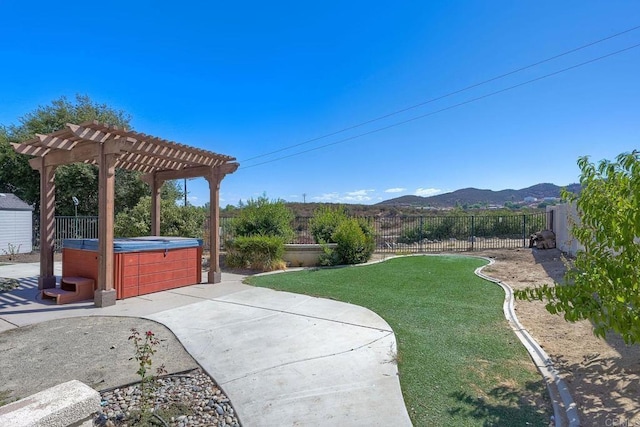 view of yard featuring a hot tub, a pergola, a patio area, and a mountain view