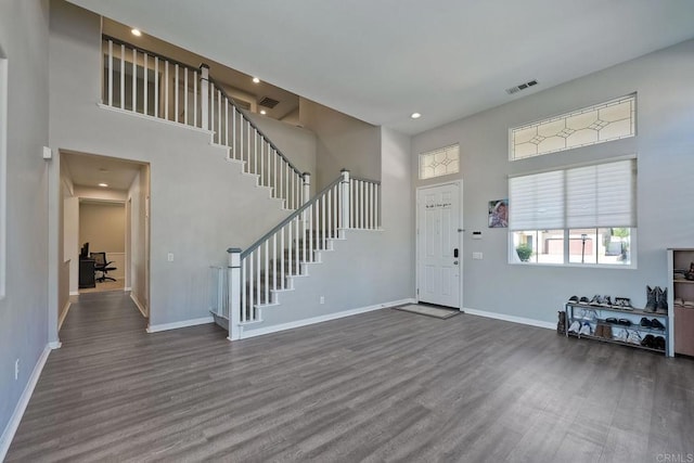 entrance foyer featuring a towering ceiling and dark hardwood / wood-style flooring