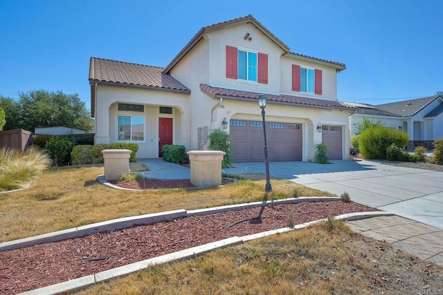 mediterranean / spanish home with a garage and a front yard