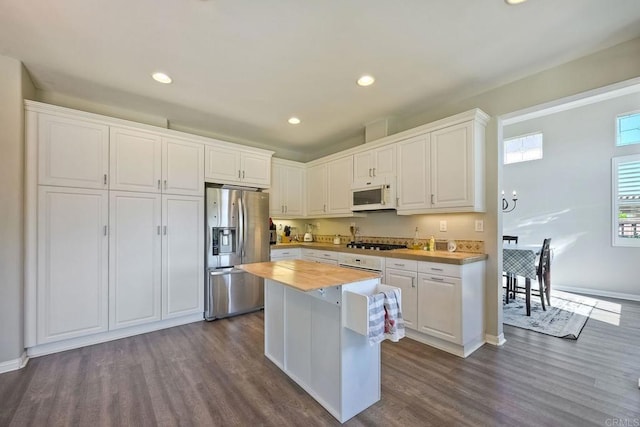 kitchen with wood counters, stainless steel appliances, dark hardwood / wood-style floors, and white cabinets