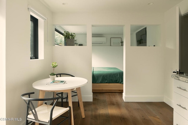 bedroom featuring a wall mounted air conditioner and dark hardwood / wood-style flooring