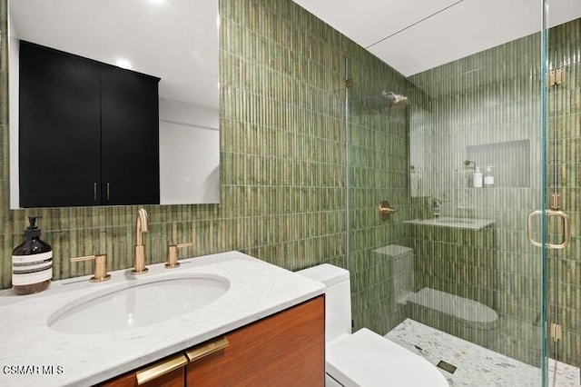 bathroom featuring tile walls, a shower with shower door, vanity, and toilet