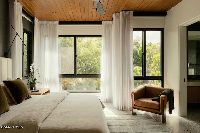 bedroom featuring ensuite bathroom, multiple windows, and wooden ceiling