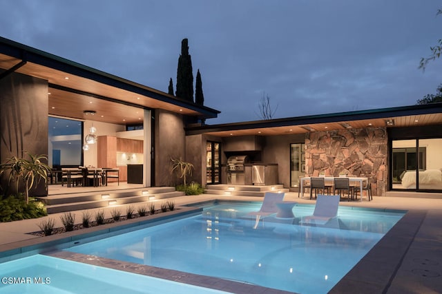 pool at twilight featuring a patio