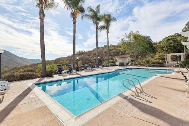 view of swimming pool featuring a mountain view and a patio