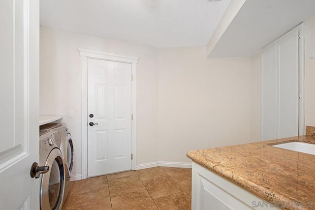 laundry area featuring sink, washing machine and clothes dryer, and light tile patterned floors