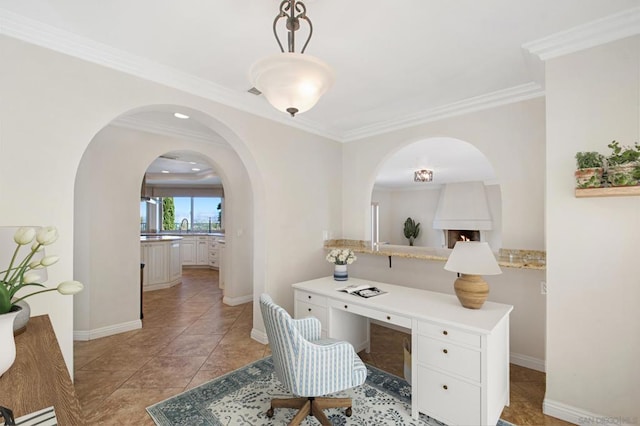 office featuring built in desk, crown molding, and light tile patterned floors