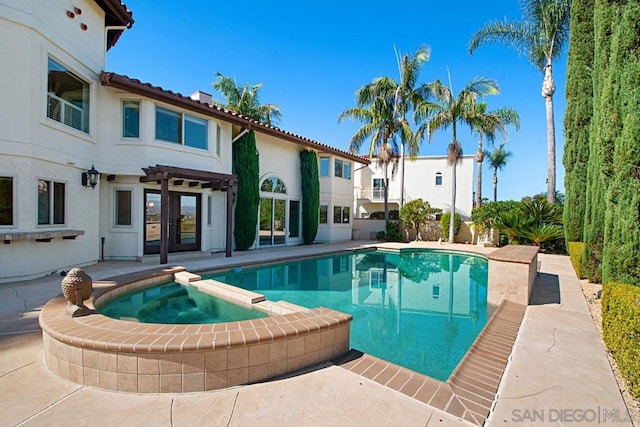 view of pool featuring an in ground hot tub and a patio