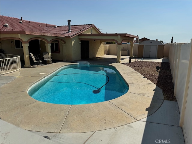 view of pool featuring a patio and a storage unit