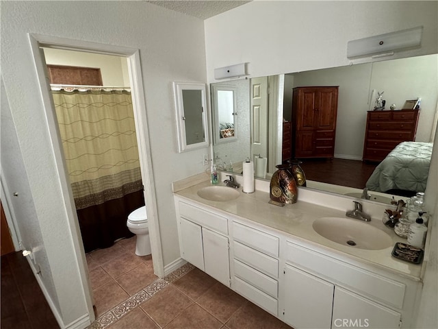 bathroom featuring vanity, toilet, curtained shower, a textured ceiling, and tile patterned flooring