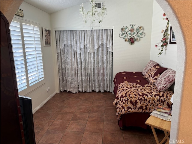 sitting room with plenty of natural light, dark tile patterned floors, and a chandelier