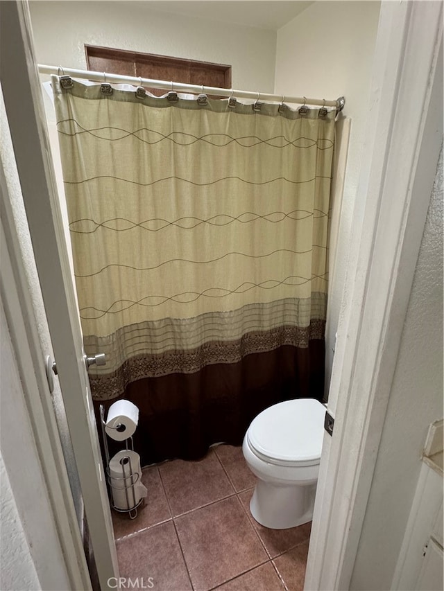 bathroom with walk in shower, tile patterned floors, and toilet