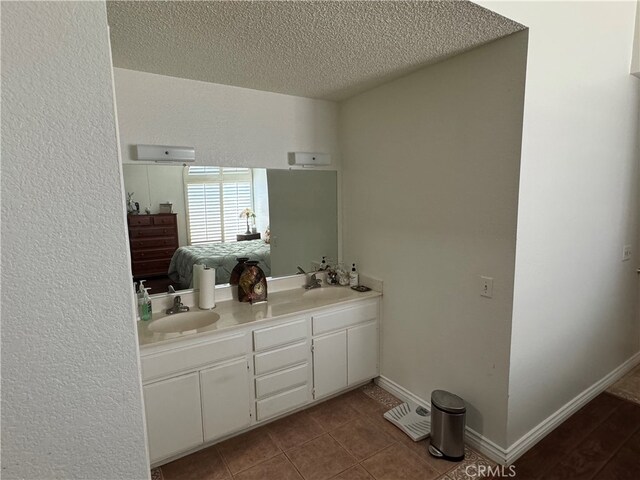 bathroom featuring tile patterned flooring, a textured ceiling, and vanity