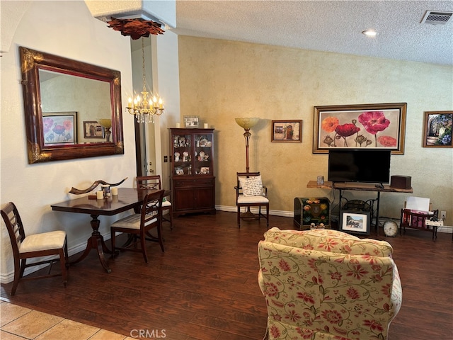 living room with a textured ceiling, hardwood / wood-style floors, and a notable chandelier