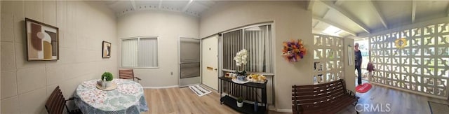 hall featuring wood finished floors and vaulted ceiling