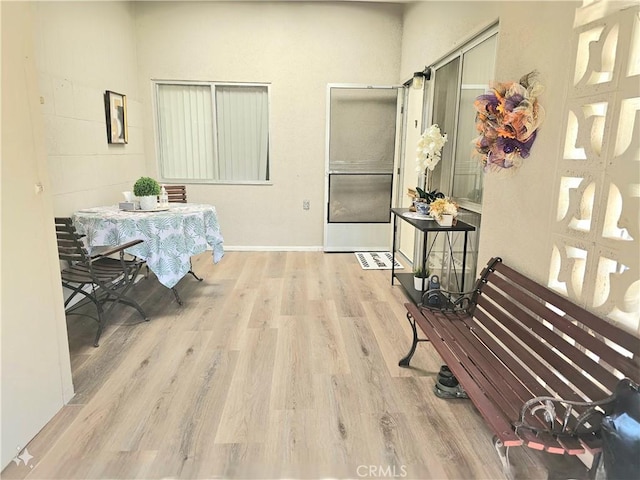 corridor with baseboards and wood finished floors