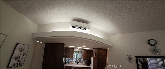 interior details with a textured ceiling and wooden walls