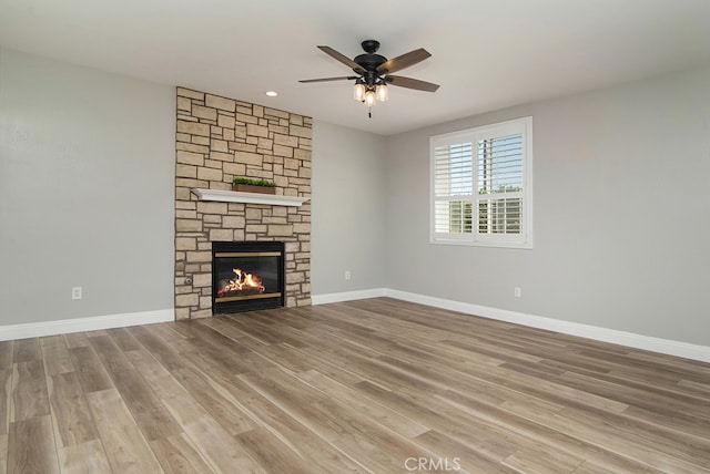 unfurnished living room with light wood-type flooring, ceiling fan, and a fireplace