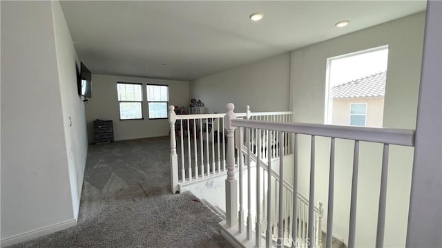 hallway with dark colored carpet