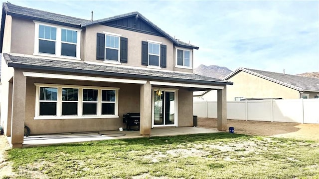 rear view of house featuring a yard and a patio area