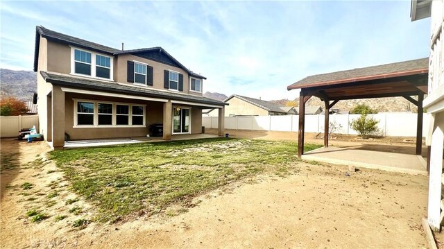 back of house featuring a yard and a patio area