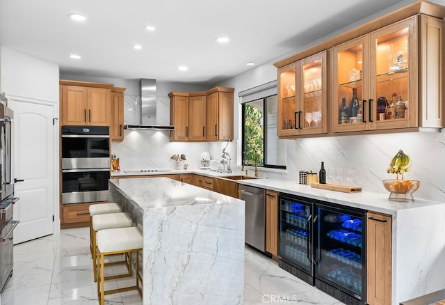 kitchen with sink, wall chimney range hood, decorative backsplash, appliances with stainless steel finishes, and light stone countertops