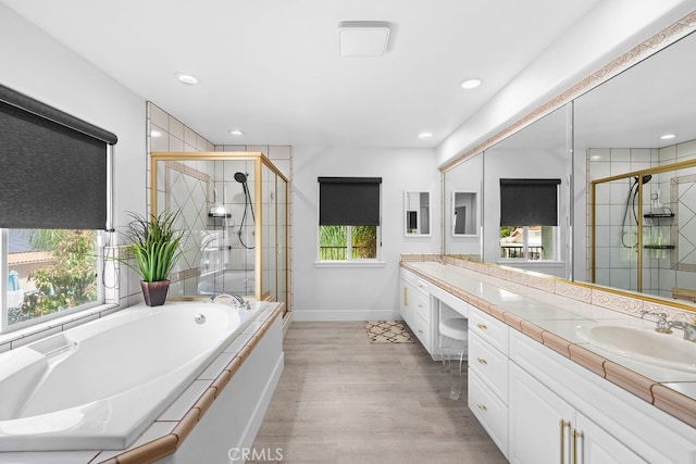 bathroom with hardwood / wood-style flooring, vanity, and separate shower and tub