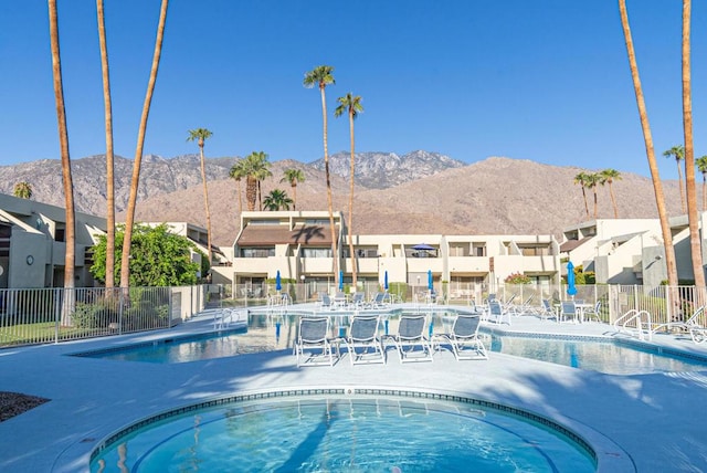 view of pool featuring a mountain view and a hot tub