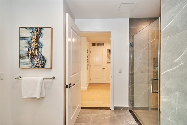 bathroom featuring hardwood / wood-style flooring and a shower with door