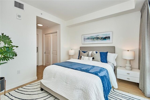 bedroom with a closet and light hardwood / wood-style flooring