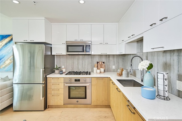 kitchen featuring tasteful backsplash, sink, white cabinets, stainless steel appliances, and light brown cabinets