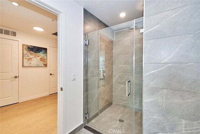 bathroom featuring hardwood / wood-style flooring and a shower with shower door