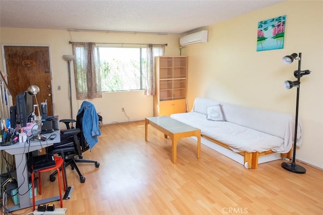 home office featuring a wall mounted air conditioner, hardwood / wood-style floors, and a textured ceiling