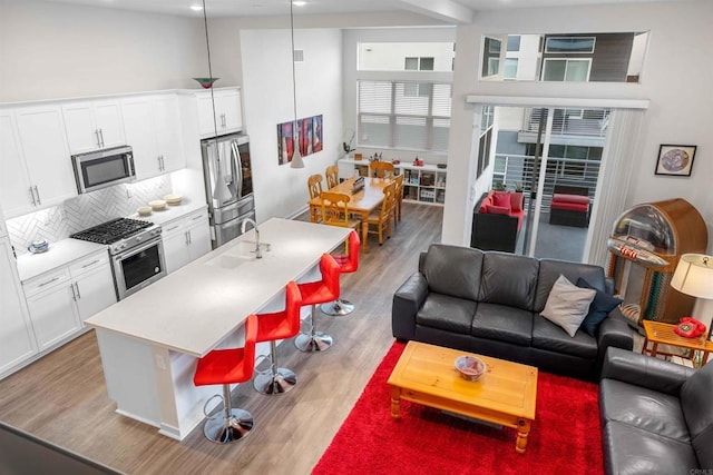 2013 Bravo Loop Unit 5, Chula Vista, CA 91915 - living room featuring light wood-style flooring and a towering ceiling