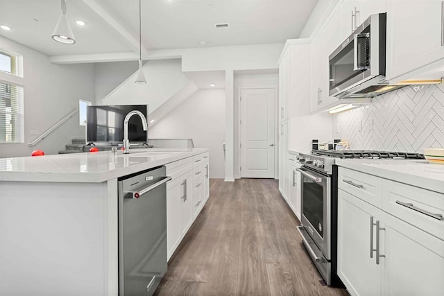2013 Bravo Loop Unit 5, Chula Vista, CA 91915 - kitchen with appliances with stainless steel finishes, tasteful backsplash, a kitchen island with sink, light countertops, and recessed lighting