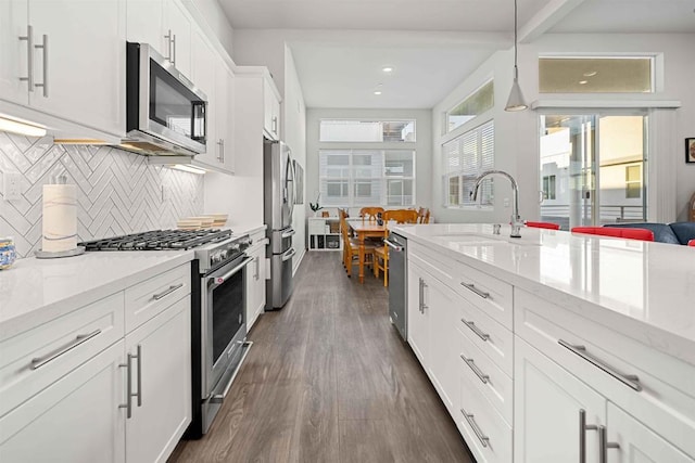 2013 Bravo Loop Unit 5, Chula Vista, CA 91915 - kitchen with appliances with stainless steel finishes, dark wood-type flooring, tasteful backsplash, white cabinetry, and pendant lighting