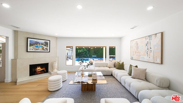 living room with a tile fireplace and hardwood / wood-style floors