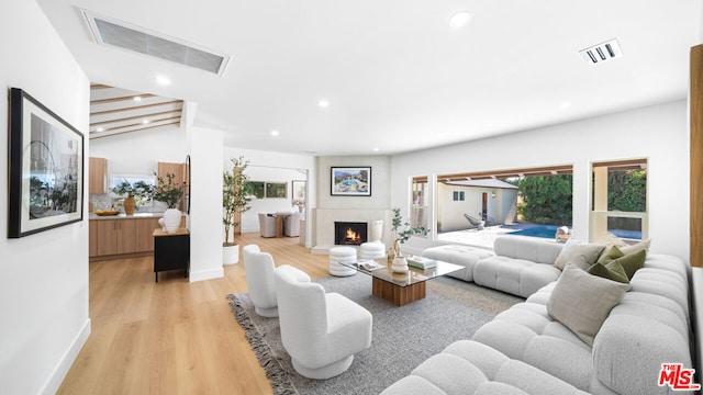 living room featuring beamed ceiling and light wood-type flooring