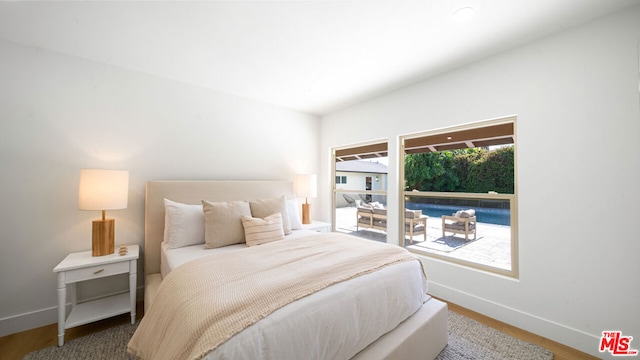 bedroom with multiple windows and hardwood / wood-style flooring