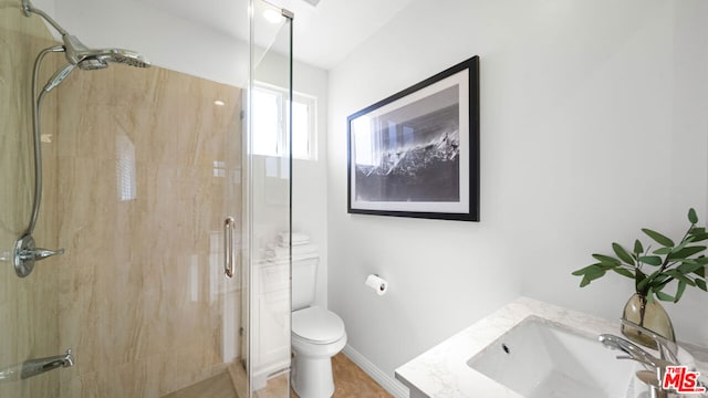 bathroom with vanity, a shower with door, and toilet