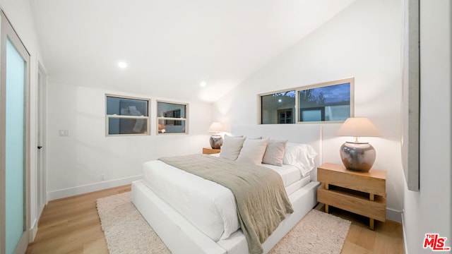 bedroom featuring vaulted ceiling and light hardwood / wood-style floors