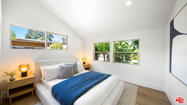 bedroom with lofted ceiling and hardwood / wood-style floors