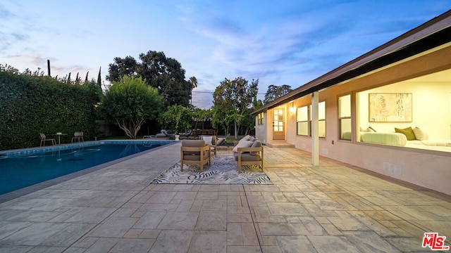 pool at dusk with a patio