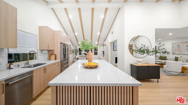 kitchen featuring decorative backsplash, appliances with stainless steel finishes, sink, and a kitchen island