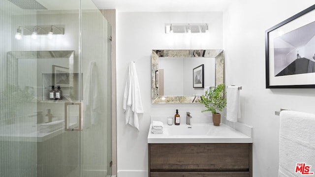 bathroom featuring vanity and a shower with door