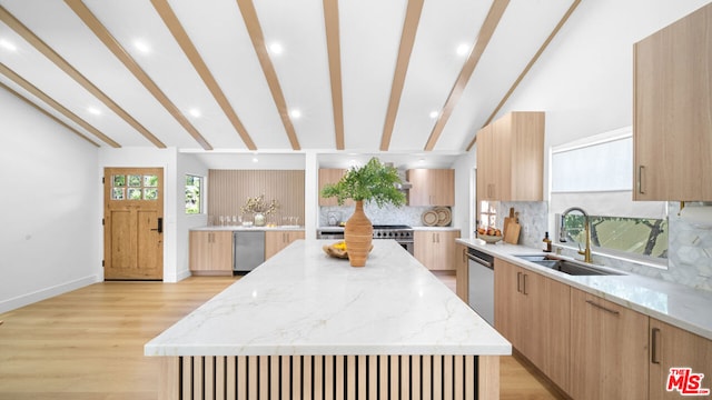 kitchen featuring light stone counters, sink, vaulted ceiling with beams, and a spacious island