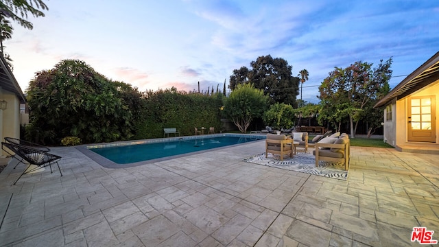 pool at dusk with a patio